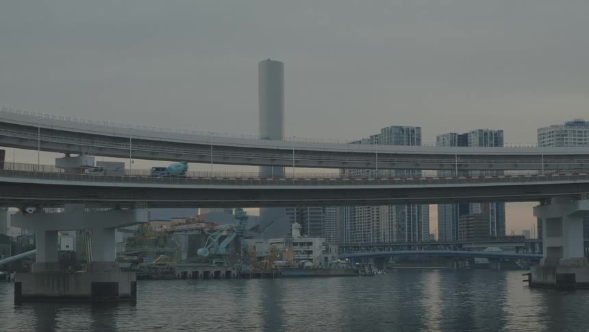 Cloudy urban landscape with a bridge over the sea and a metropolis with buildings in the background