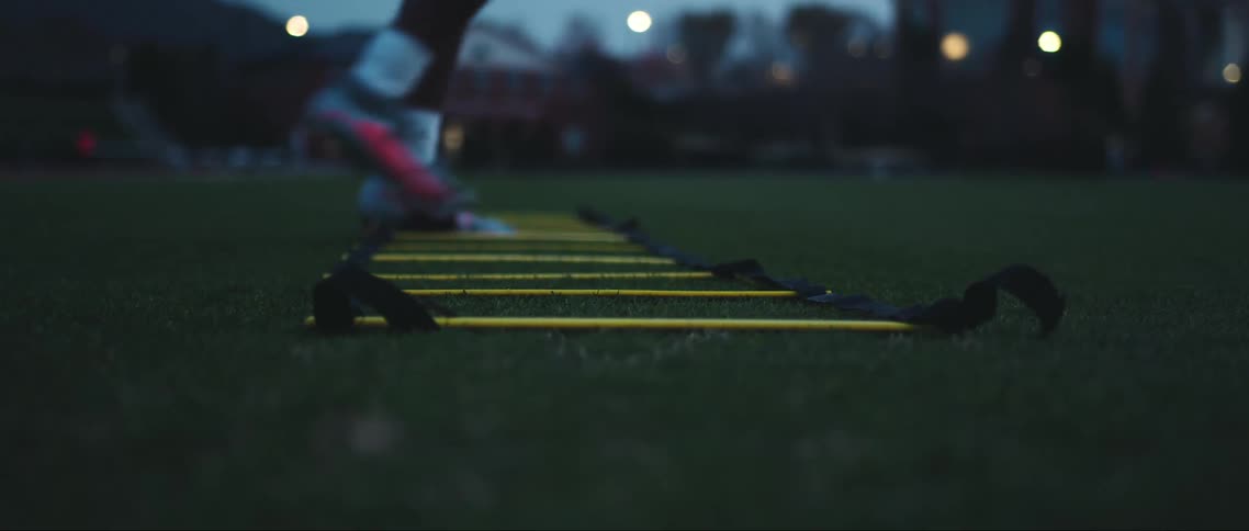Feet of a boy with football boots doing training on the grass