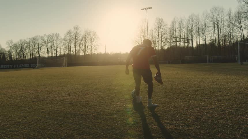 Young man sitting on a soccer field to put on his soccer cleats