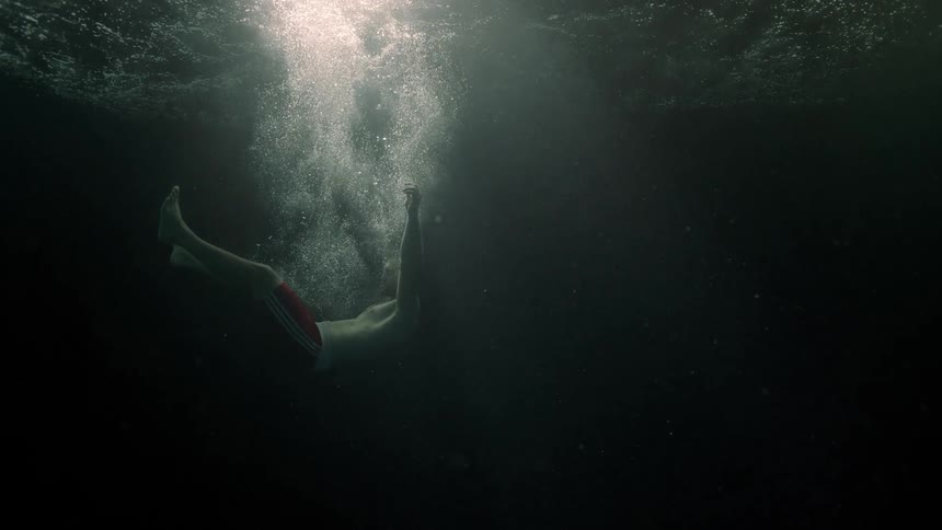 A man falls in the water and sinks