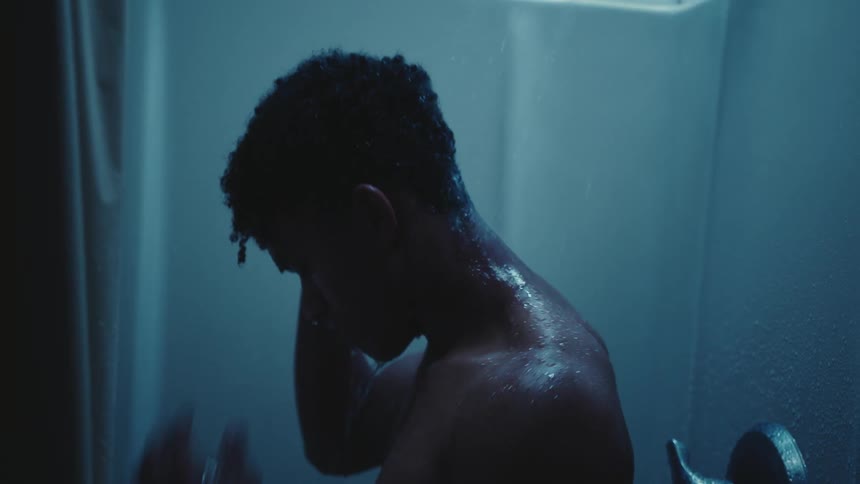 A man is showering in the stall