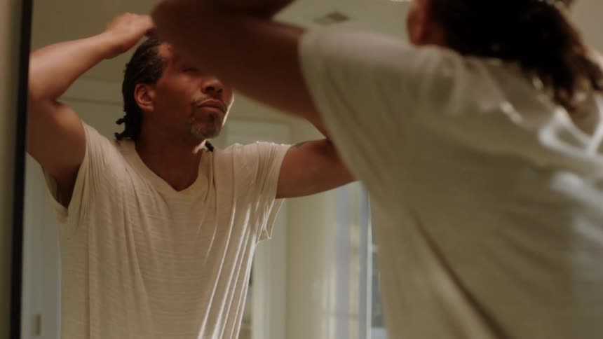 A man is washing his face in the mirror