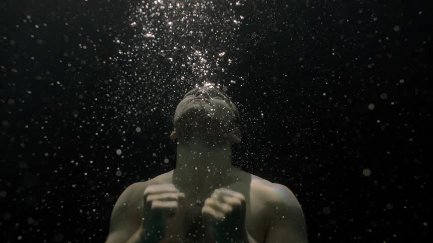 Man submerged in water rising towards the surface