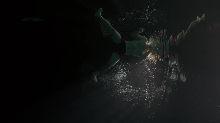 Man submerged in water swimming