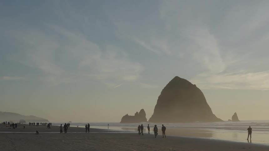 People walking on the beach sand in the late afternoon
