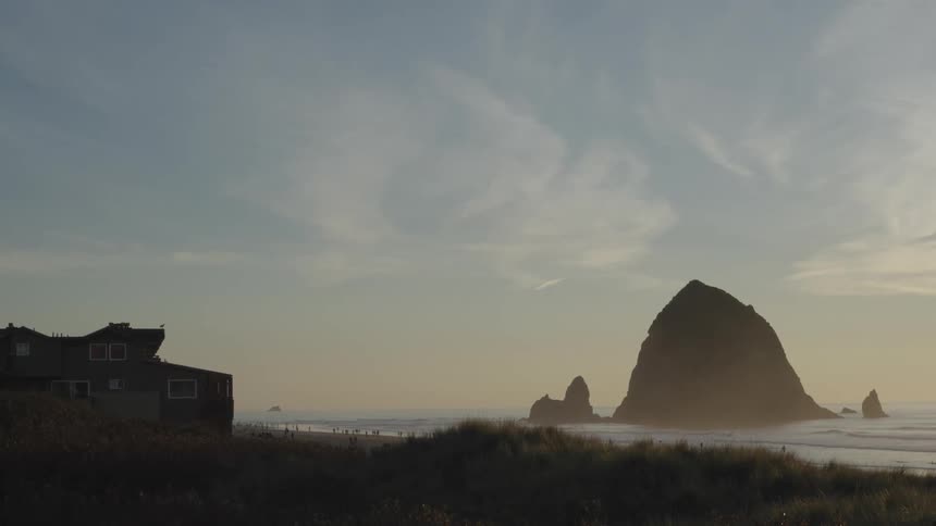 Landscape of a beach at dawn with a house in the background