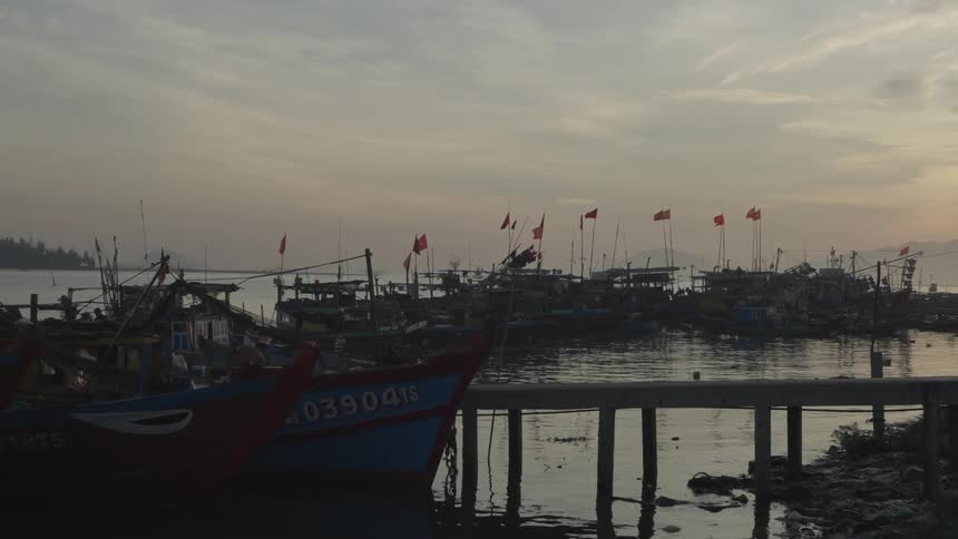 Small wooden boats moored at the dock on a sunrise