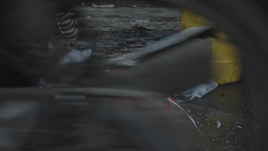 Person catching fish in a red box on the floor and placing it in a bag