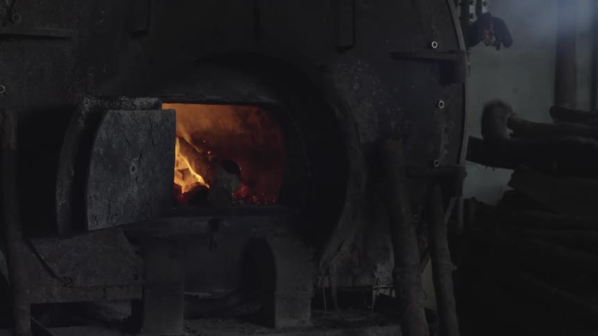 Man placing wood inside an industrial oven
