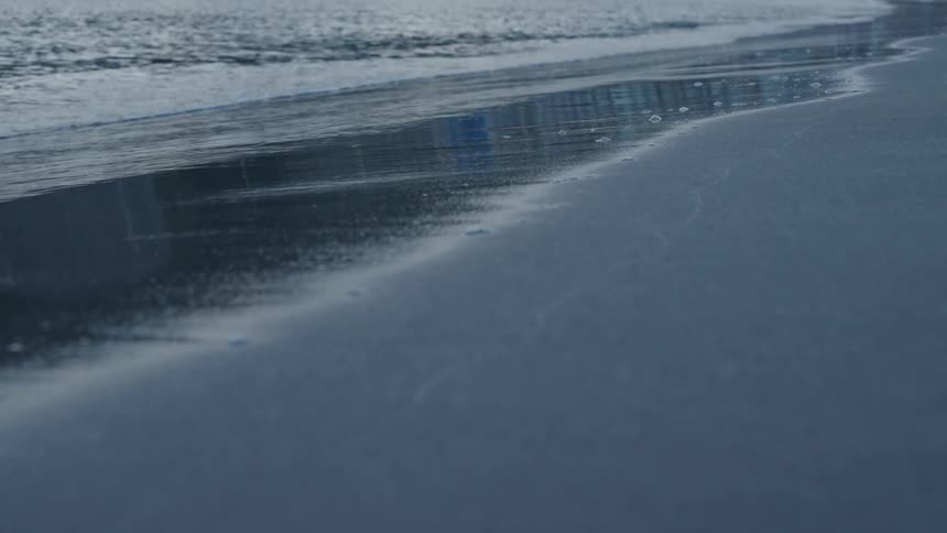 Waves of a calm sea arriving on the beach sand