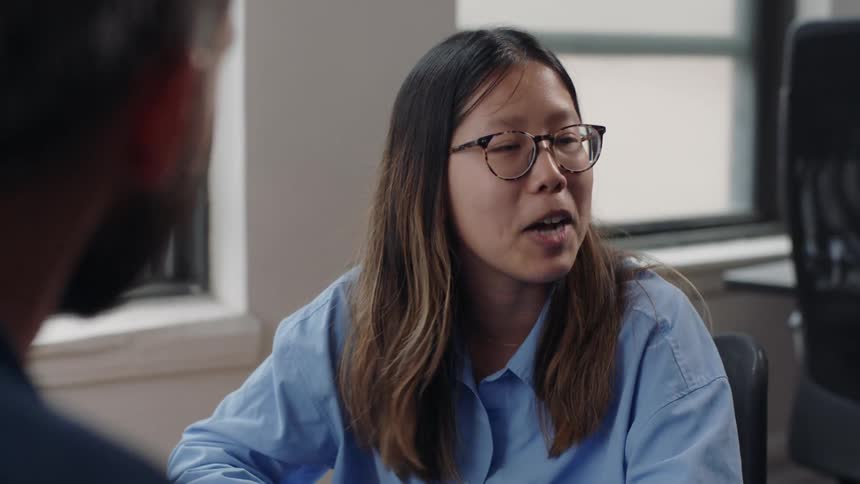 Woman sitting talking to a man in an office room