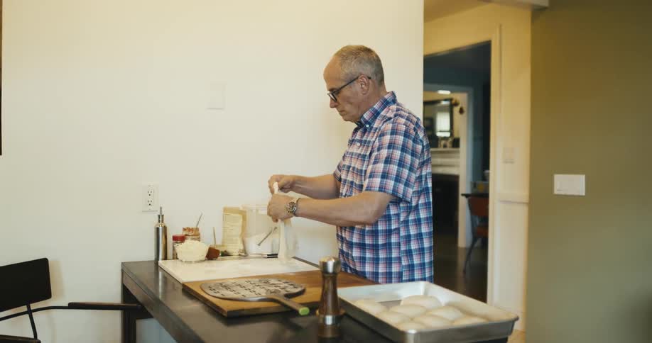 Standing man cooking and preparing a pizza dough