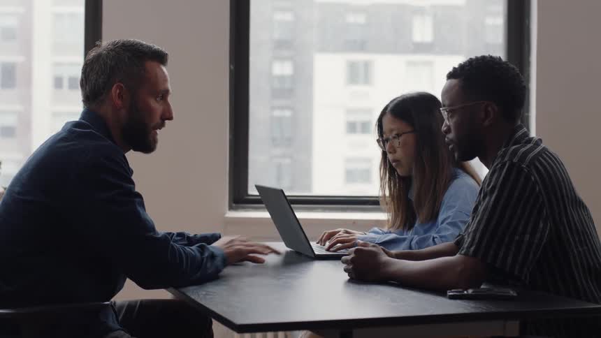 Three people have a meeting in an office