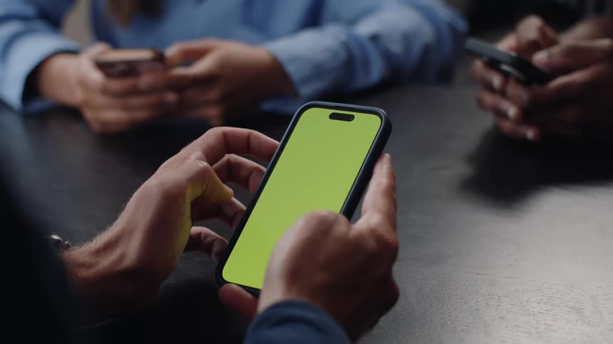 Close up of the hands of three people interacting with smartphones