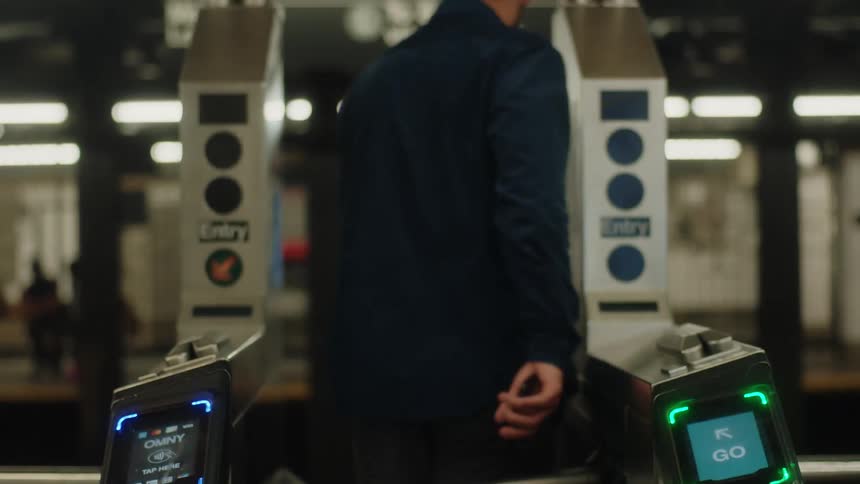 Man crossing the turnstile of a subway station and entering