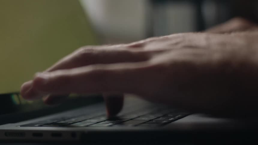 Closeup on pair of hands typing on a laptop