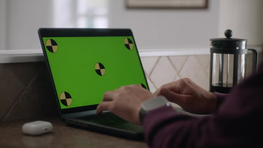 A man is typing on his laptop