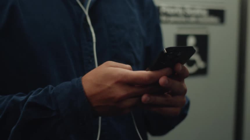 Man with sunglasses using his cell phone on a train