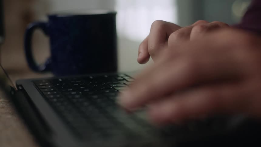 Closeup on a pair of hands typing on a laptop