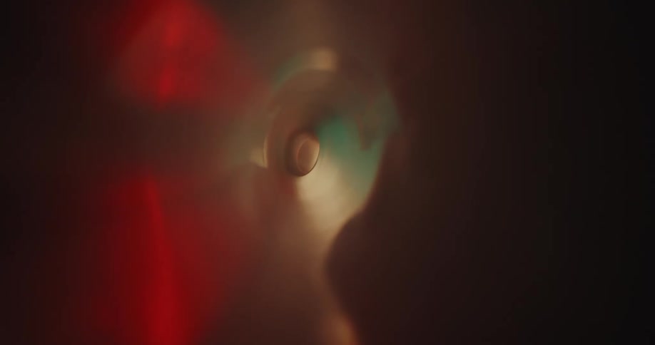The interior of a semi translucent plastic tube with green and red lights reflecting on its walls