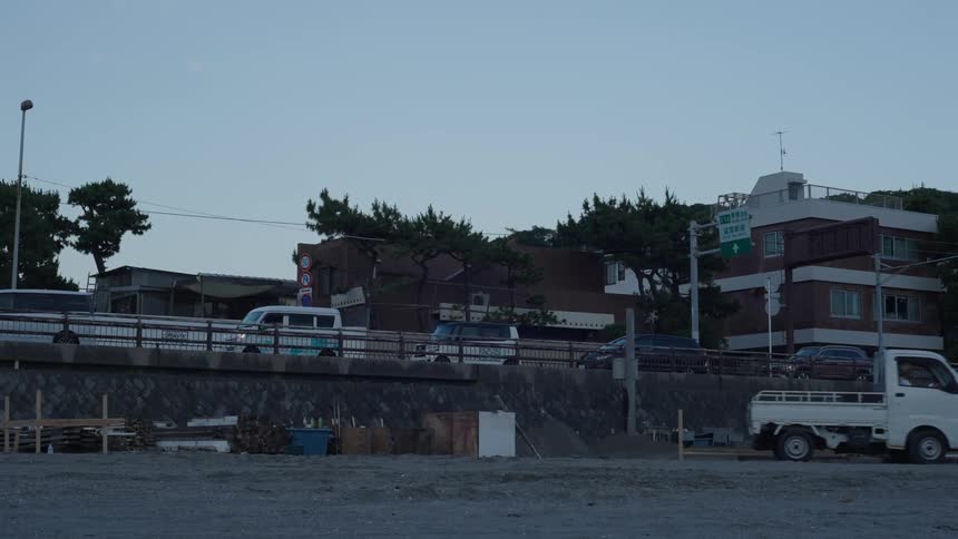 Small truck moving and in the background city buildings