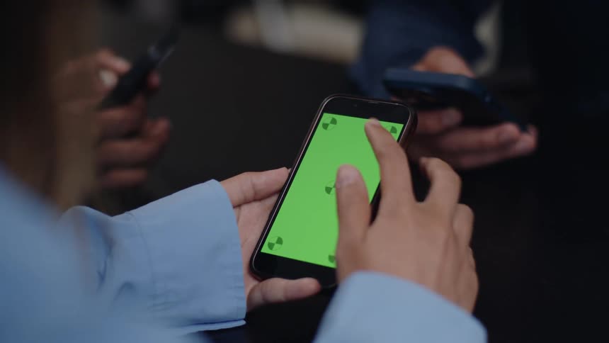 Closeup of the hands of three people using a smartphone