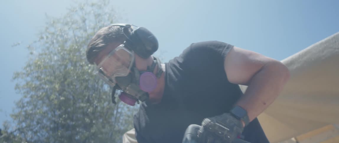 Man in protective equipment working with a jackhammer