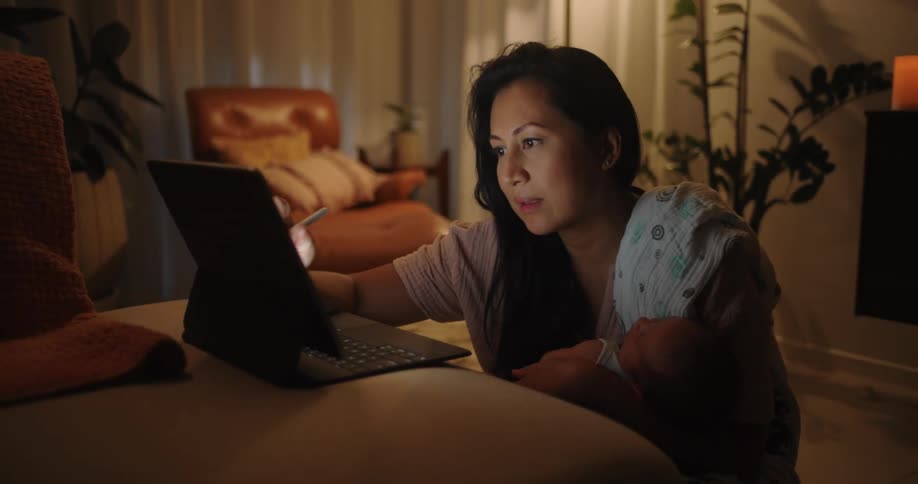 Woman in the living room working on a laptop at night