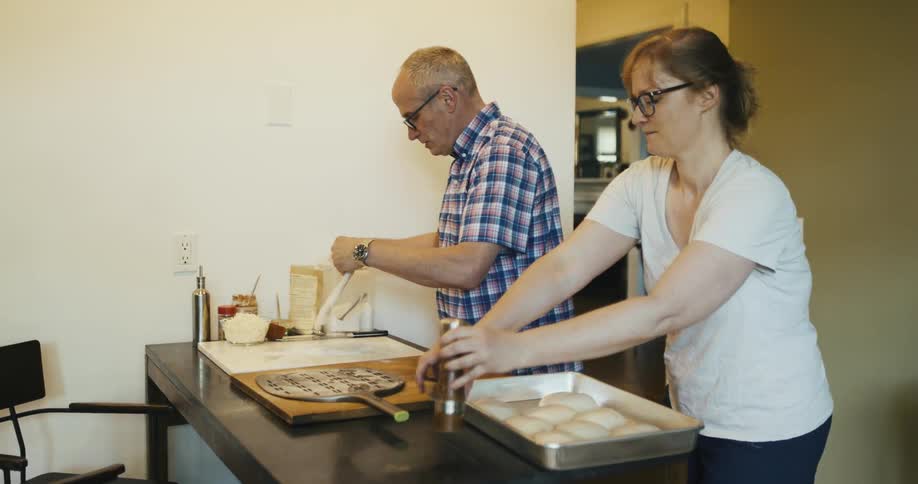A father and daughter cooking pizza together