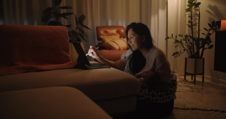 A woman is using a stylus on her tablet