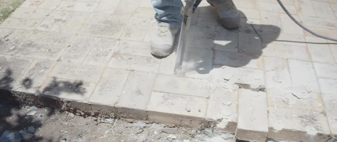 Man wearing protective equipment and working with a jackhammer