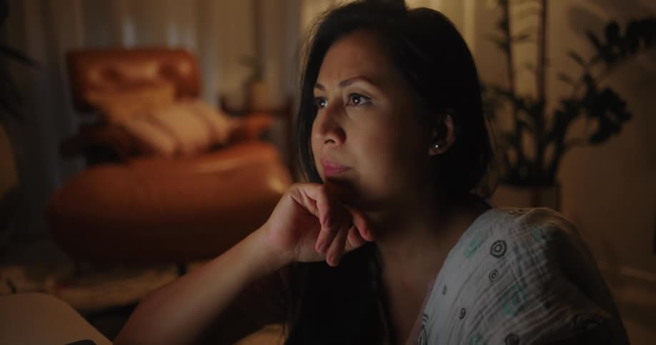 Mother with her daughter drinking on her lap sitting on the floor in the living room and using a tablet
