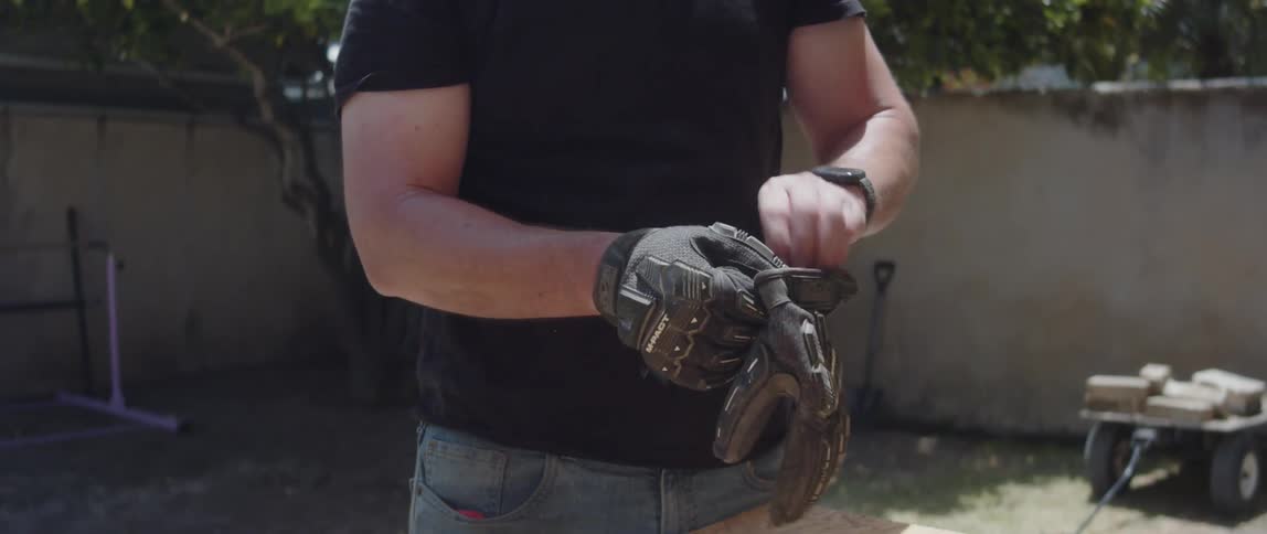 A construction worker puts on his gloves
