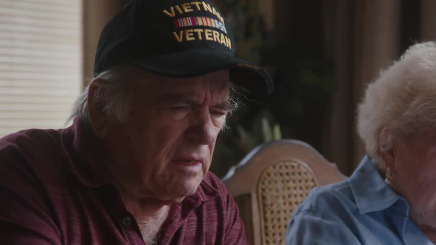 Elderly man and woman sitting at a table talking