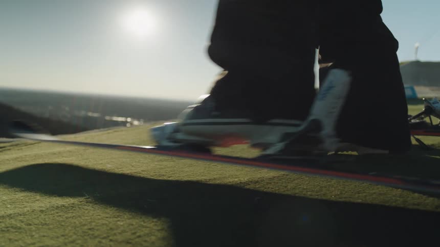 A skier locks his foot into a ski