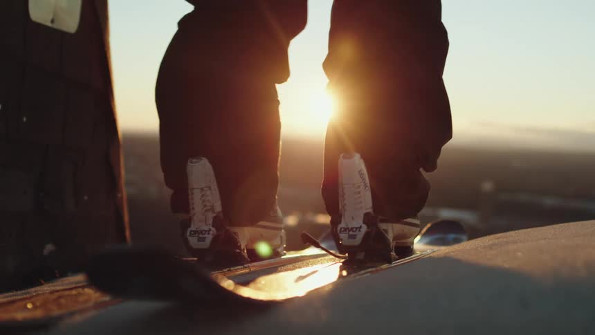 A person placing their snowboards on their feet
