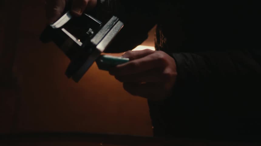 Pair of hands applying paraffin to a metal object