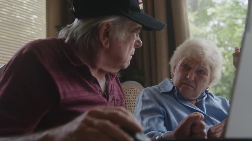 An elderly woman gets angry with her husband over some paperwork