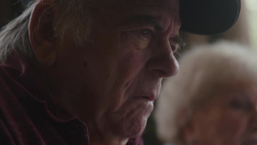 Two elderly people appear anxious or off as they engage in conversation