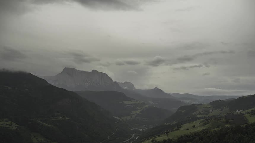 Wide landscape of mountains with green valleys and a cloudy sky that dusk and dawn in a cloudy way