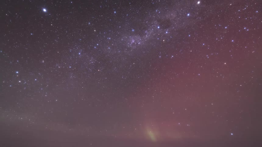 Aurora borealis with shades of green and pink illuminating the starry night sky