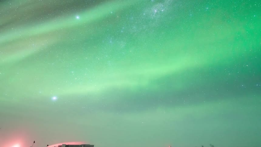 The night sky illuminated by the vibrant green and purple hues of the aurora borealis