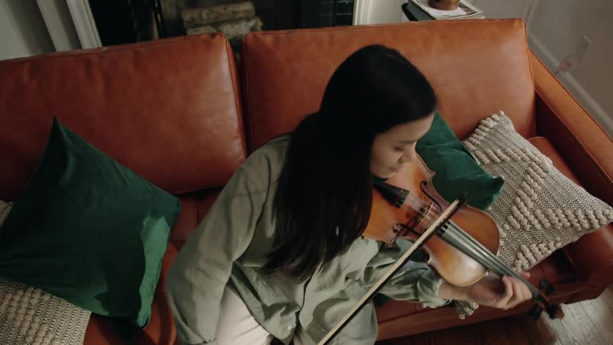 Woman sitting playing violin