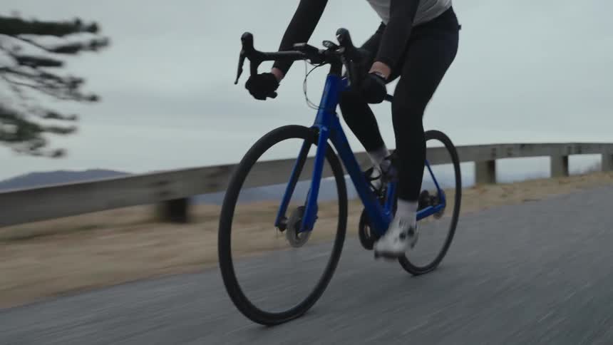A man rides a bicycle along a rural road