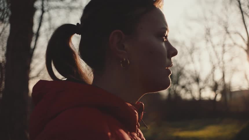 A woman looks around at the trees