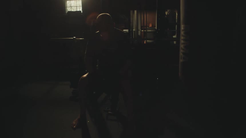 A man gets up from the weight bench