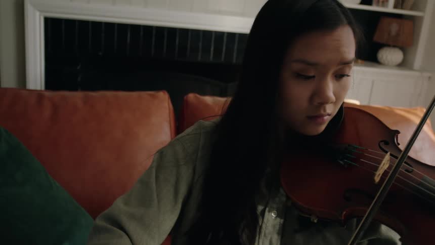 Young woman sitting playing the violin