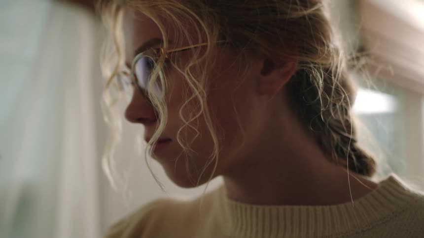Portrait of a young blonde woman holding a concentrated brush