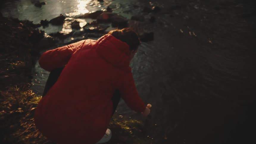 A woman places a flower in the stream