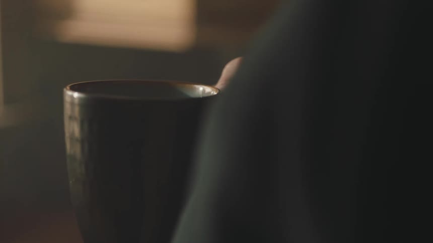Close up of a person holding a mug seen from the back